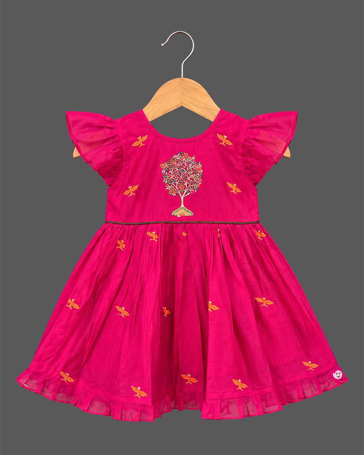 Baby party wear dress with intricate tree embroidery, frill sleeves, and pleated hemline.