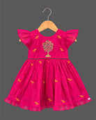Baby party wear dress with intricate tree embroidery, frill sleeves, and pleated hemline.
