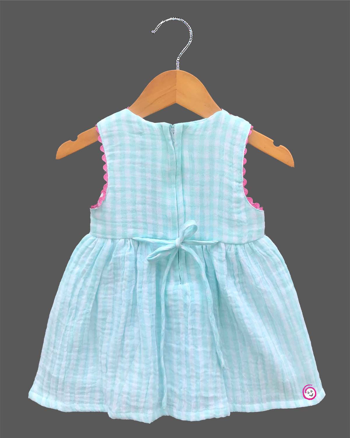 Sleeveless gingham cotton tunic dress for young girls featuring floral and butterfly embroidery with scalloped lace trim.