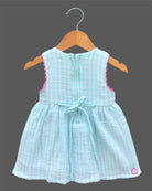 Sleeveless gingham cotton tunic dress for young girls featuring floral and butterfly embroidery with scalloped lace trim.