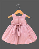 Dusty rose pink toddler net party frock featuring a large floral applique and sleeveless design for girls.
