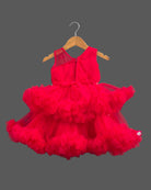 Sleeveless net ruffle baby party wear dress with high-low hemline and floral chest applique.