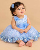 Girls embellished mesh frock with sequins, pearl brooch, floral waist appliqué, and layered net flare.
