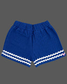 Sleeveless A-line top with decorative bow paired with wave-trimmed shorts.