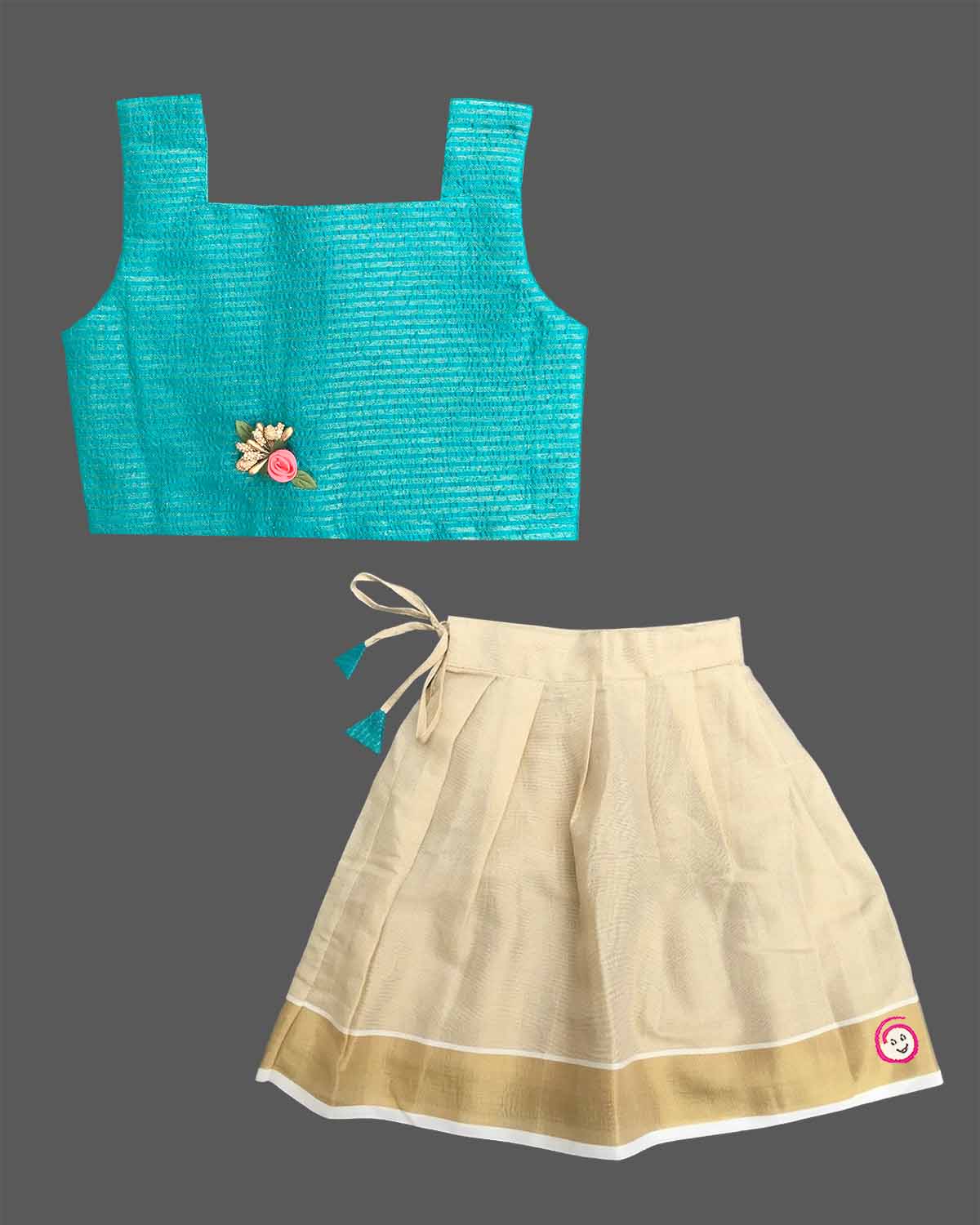 Little darling two-piece traditional festive ethnic outfit with floral chest brooch and pleated zari bordered skirt.