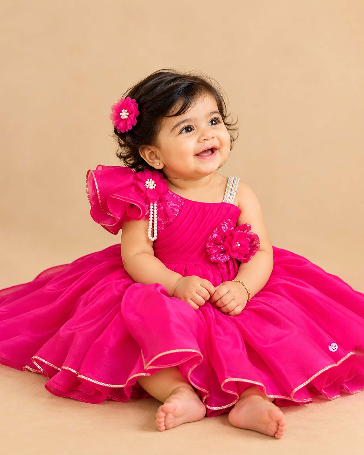One-shoulder pleated organza baby party wear dress with ruffle sleeve and floral applique.