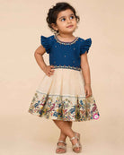 Infant cotton silk  frock in teal blue and cream with multicolored bird and floral kalamkari border work, neckline embroidery, and ruffle sleeves