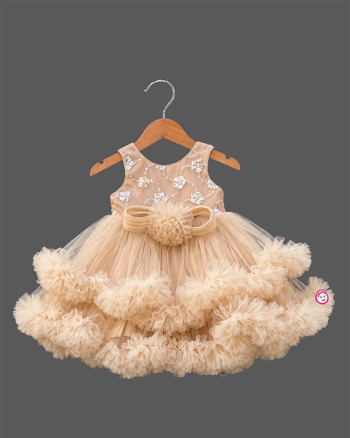 Beige cream net party frock for girls featuring sequin floral embroidery, sleeveless bodice, and tiered ruffle high-low hem design