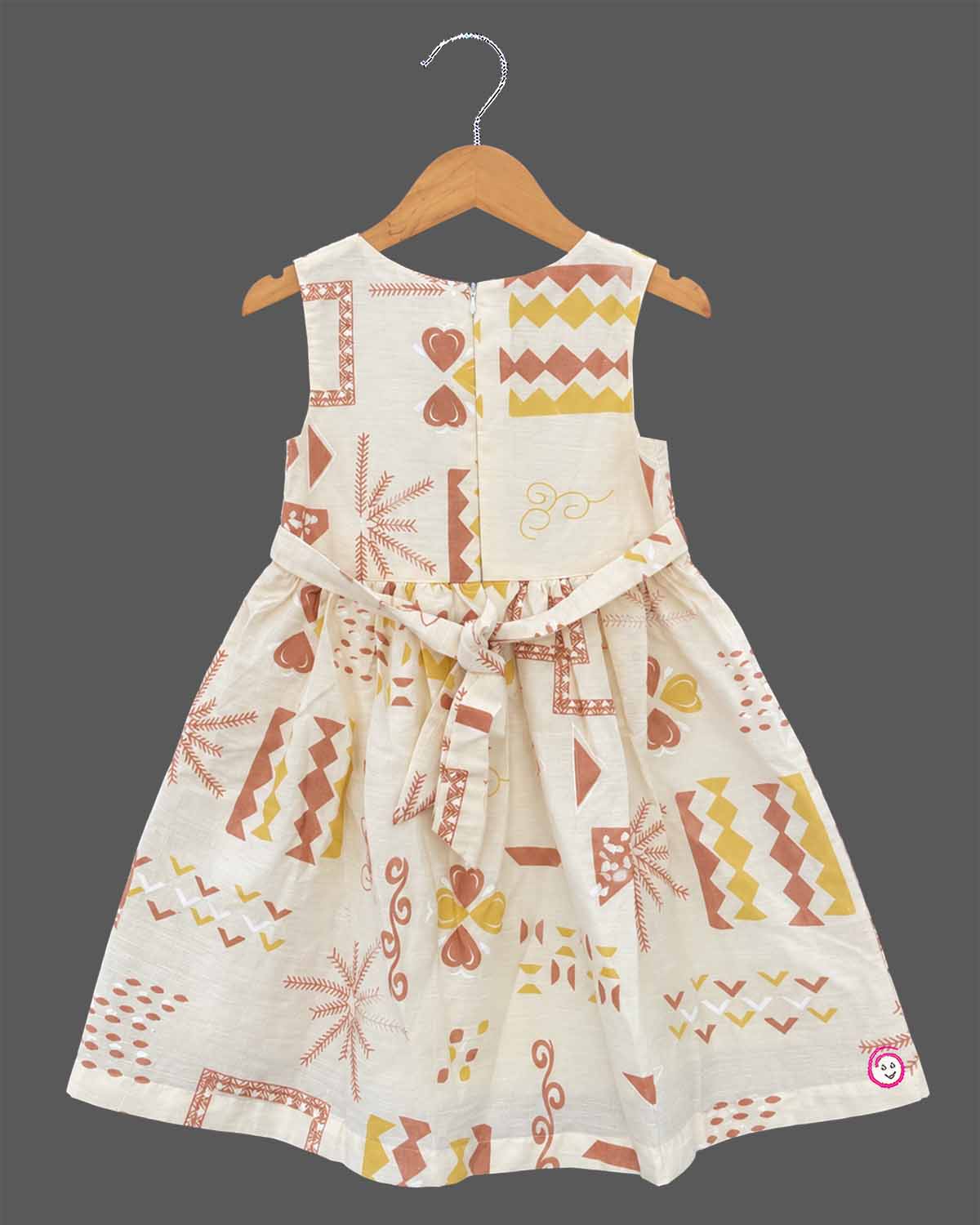 Little Girl Casual Frock featuring a cream dress with patterns and a peachish-pink textured shrug/jacket with a flower brooch and tie-up front.