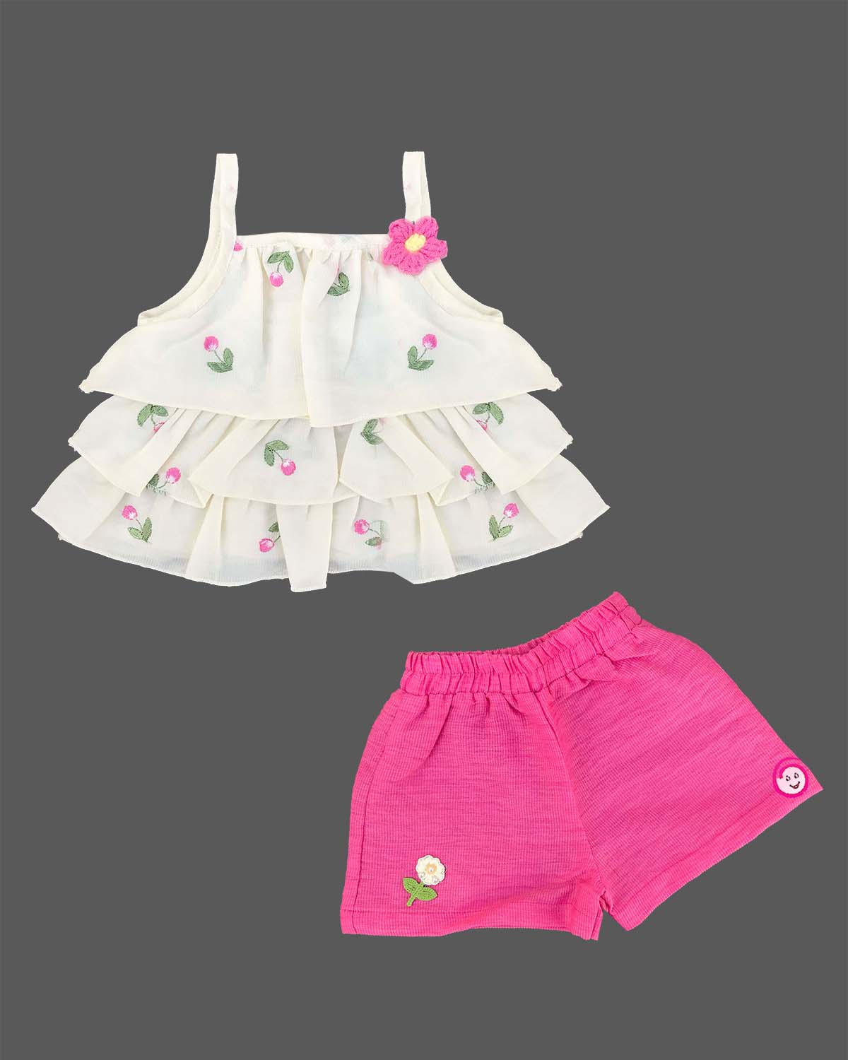 Cream tiered top with pink floral embroidery and bright pink shorts baby girl top and shorts set for summer vacations, playdates, and park outings