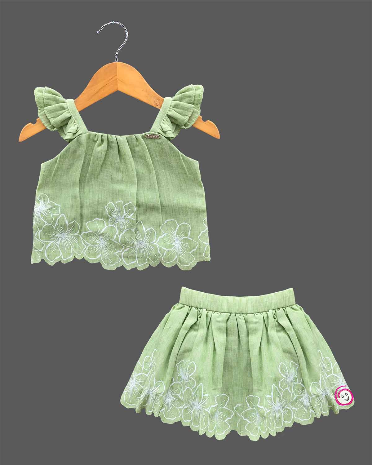 Sleeveless ruffle strap top paired with a flared embroidered skirt for a young fashionista.
