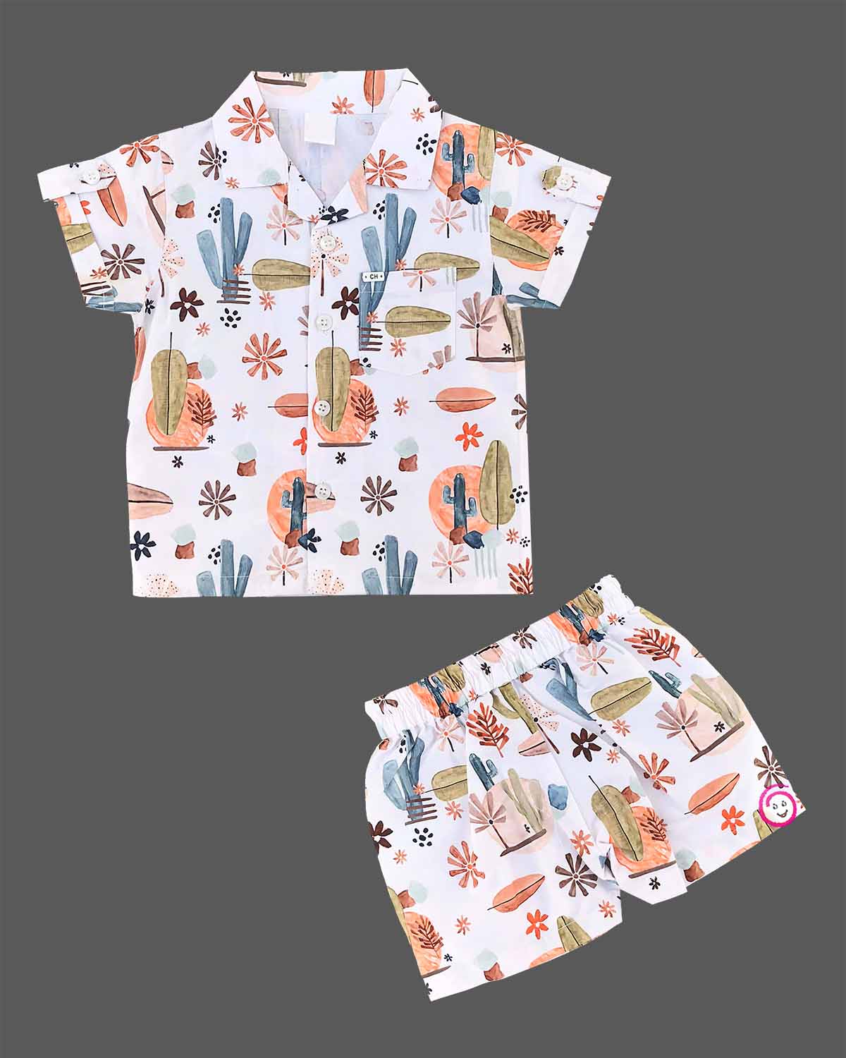 Boys 2-piece cotton casual co-ord set featuring a short-sleeve collared shirt and matching shorts in white with cactus, palm leaves, and desert botanical prints