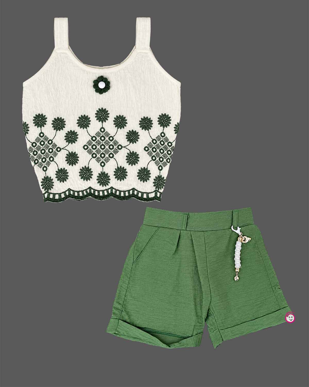 Girls sleeveless embroidered top with scalloped hem paired with pleated cuffed shorts and decorative charm.