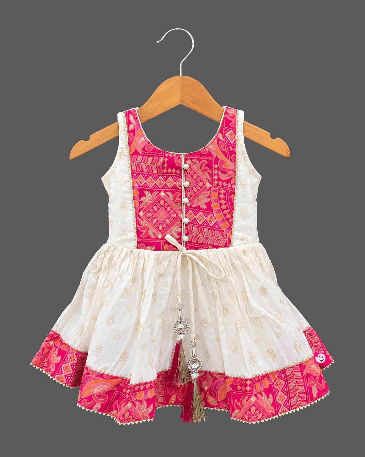 Sleeveless printed short kurta and flared tiered kids sharara set with gota trim details.