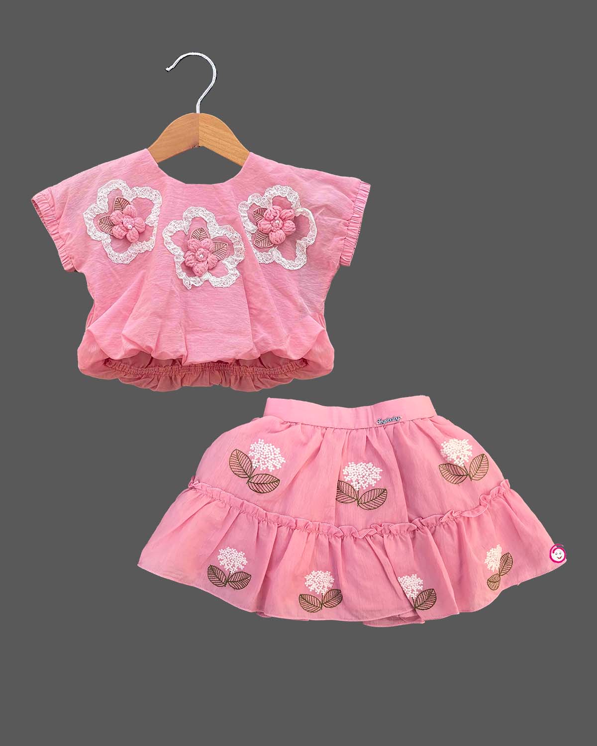 Textured floral applique blouson top paired with embroidered tiered skirt baby party wear dress.