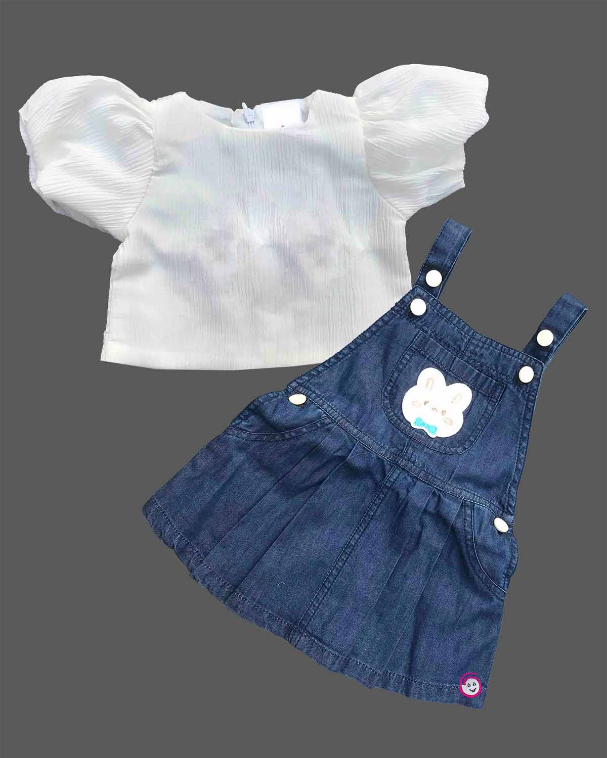 Toddler girl outfit set featuring textured puff sleeve blouse and denim pinafore dress with bunny patch detail and pleated skirt
