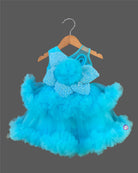 Glittering embellished flower applique party frock for little princess with ruffled high-low net skirt displayed on a wooden hanger.