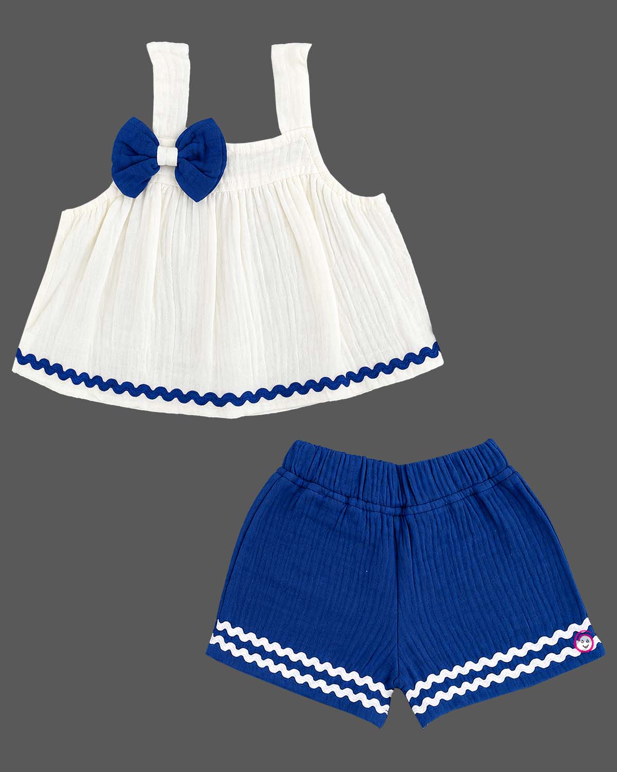 Sleeveless A-line top with decorative bow paired with wave-trimmed shorts.