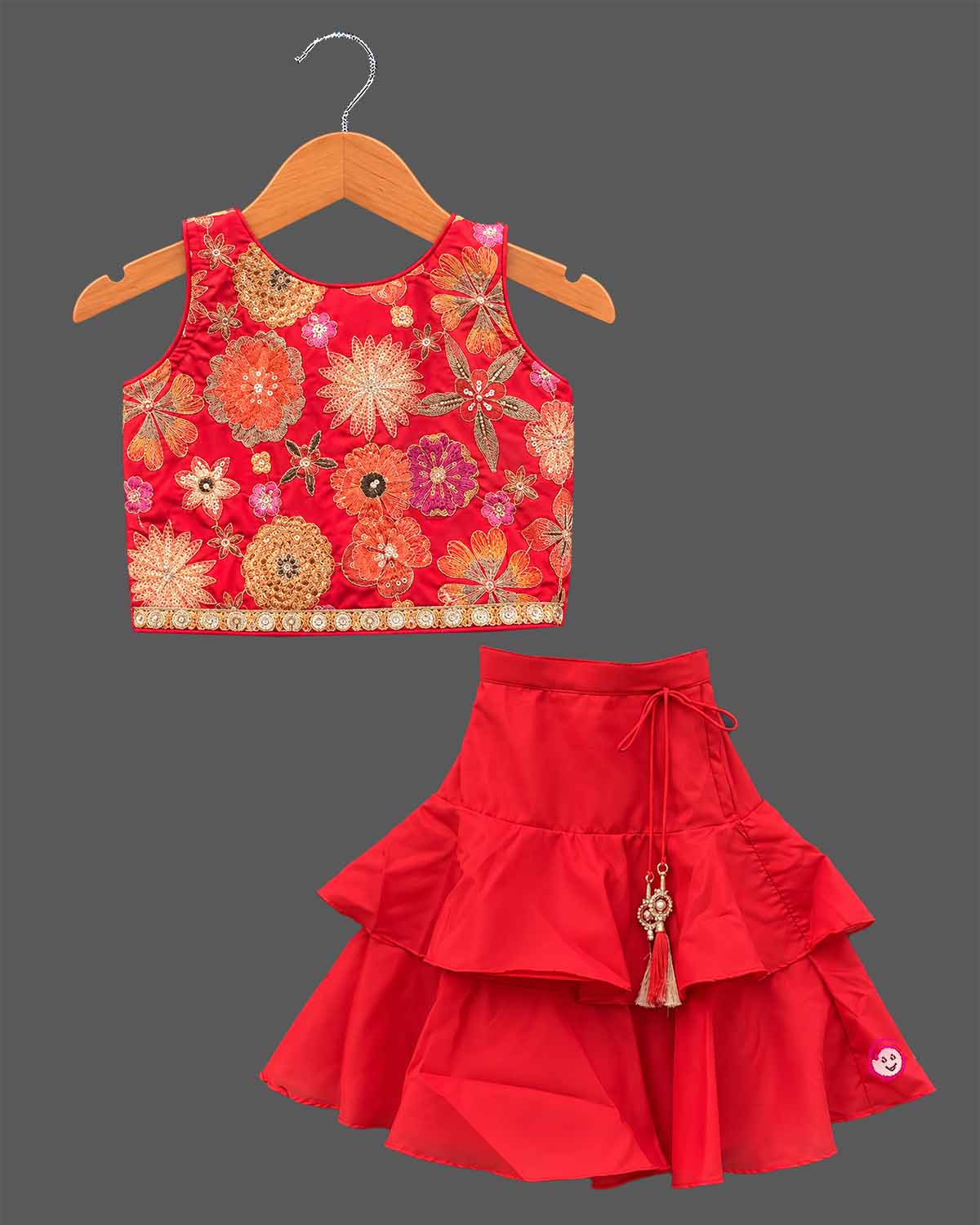 Girls floral embroidered sleeveless choli paired with a tiered ruffled skirt and tassel drawstring accent.