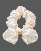 Off-white satin and organza party frock for baby girls featuring a large satin rose, embroidered leaf detail, and pearl embellishments