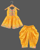 Sleeveless bandhani print short kurti with mirror work yoke paired with pattu langa for kids dhoti pants.