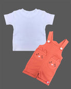 Little boy wearing cute character pocket dungaree shorts with soft solid t-shirt.