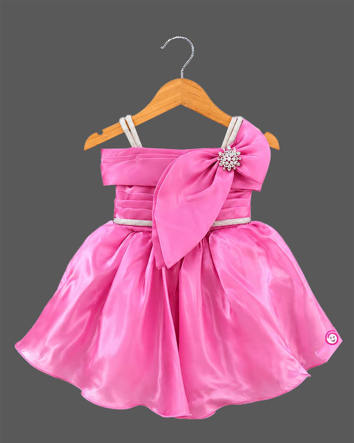 Pink satin and organza princess style party frock for baby girl featuring oversized side bow, rhinestone shoulder straps, and crystal brooch for first birthday outfit for girl and wedding celebrations