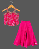 Kids sharara set featuring strappy embroidered top with mirror work trim and wide flared palazzo pants.