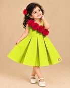 One-shoulder pleated party frock adorned with cascading fabric roses and green leaf details for festive celebrations.
