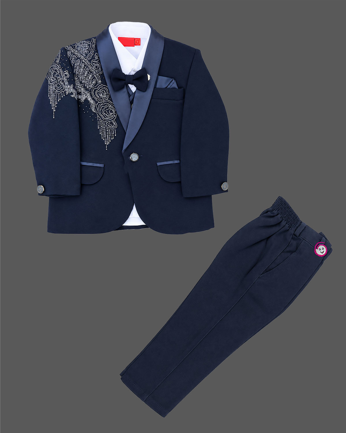 Blue boys formal suit with silver shoulder embroidery, white shirt, and bowtie