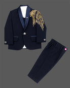Boys blue designer tuxedo suit set featuring a shawl collar blazer with intricate gold shoulder embroidery, shirt, waistcoat, bow, and matching blue formal pant