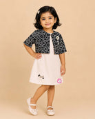 Black and white geometric jacket over a cream baby girl cotton midi dress for family dinners, evening outings, and smart casual wear