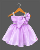 Lavender satin and organza party frock for baby girl featuring oversized side bow, rhinestone shoulder straps, and crystal brooch for birthday and wedding celebrations