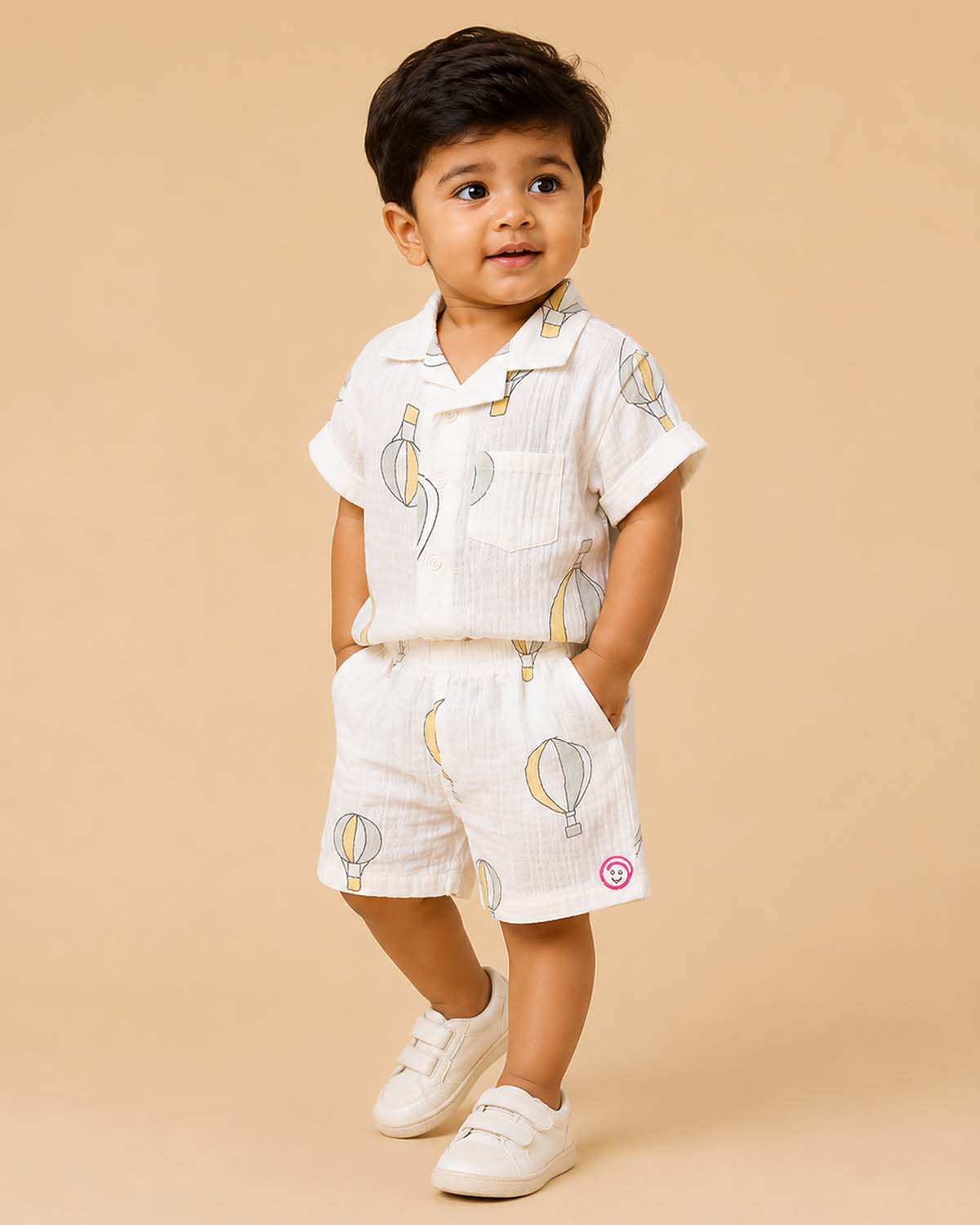 Boys 2-piece cotton casual co-ord set featuring a short-sleeve collared printed shirt and matching shorts in white with pastel yellow and grey hot air balloon prints