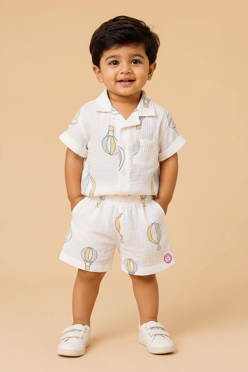 Boys 2-piece cotton casual co-ord set featuring a short-sleeve collared printed shirt and matching shorts in white with pastel yellow and grey hot air balloon prints