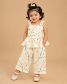 A cute patterned cotton co-ord set for baby girls featuring a sleeveless peplum top with ruffle straps and matching pants on a hanger.