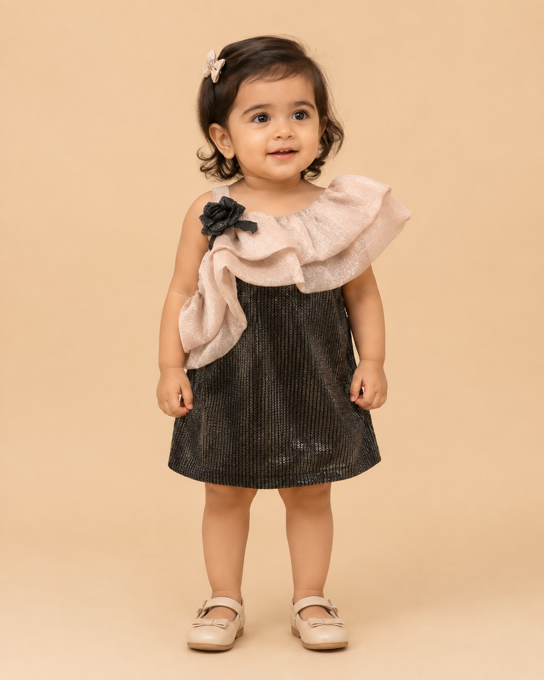 One shoulder girls toddler sequin party dress with light brown shoulder ruffle, black sequin body, and a black rose detail, hanging on a wooden hanger against a dark grey background, with a small OPUS RKID logo in the corner.  