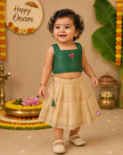 Young fashionista wearing traditional festive two-piece set featuring ribbon rose detail and pleated zari striped skirt.