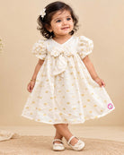 Little princess jacquard frock with front bow accent puff sleeves and woven circular motif detail