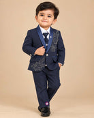 Navy blue formal tuxedo suit set for boys with crystal embellishments, shawl collar jacket, white shirt, tie, and pant for wedding party