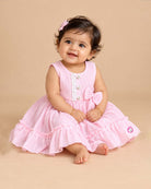 Sleeveless textured crinkle cotton frock with waist bow accent, lace trim, and tiered ruffle hemline for girls.