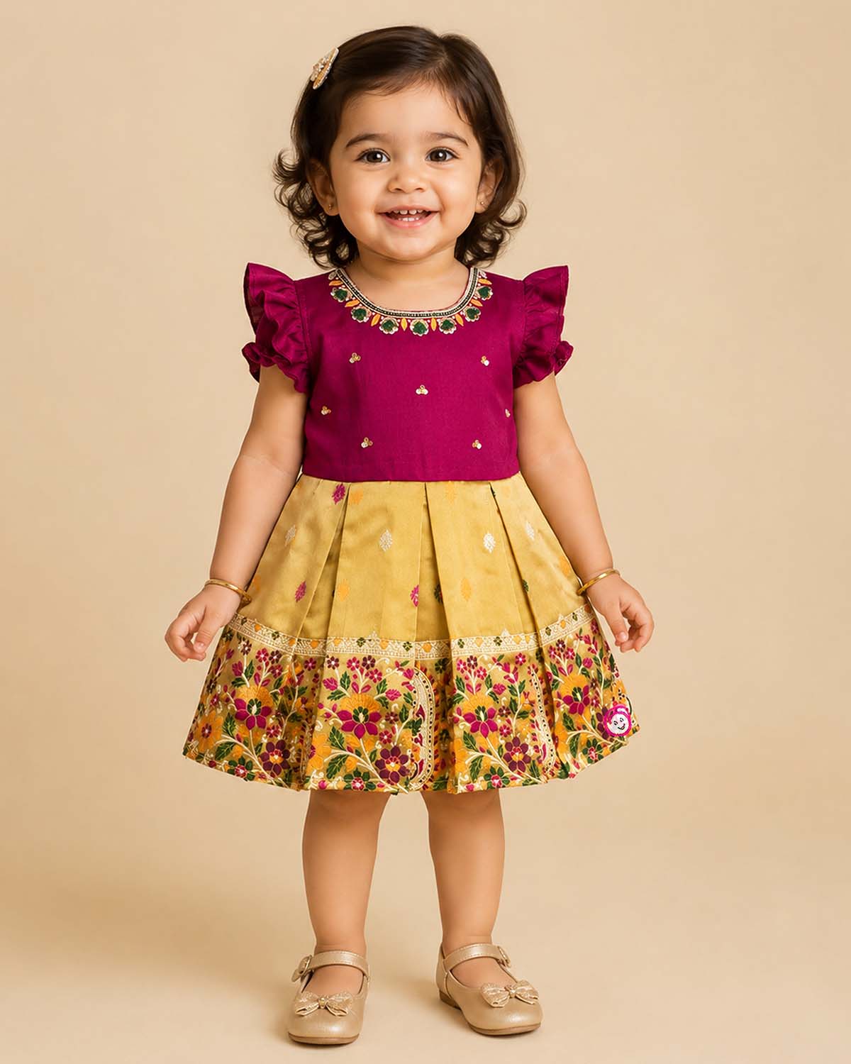 Detailed front view of a baby girl's luxury cotton silk frock with exquisite hand-embroidered neckline, ruffled sleeves, and a heavy woven zari pattu border for festive wear.