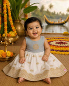 Sleeveless traditional festive attire for toddlers styled with metallic border motifs and chest embroidery.
