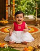 Sleeveless traditional festive attire for toddlers featuring an embroidered central emblem and a voluminous flared skirt.