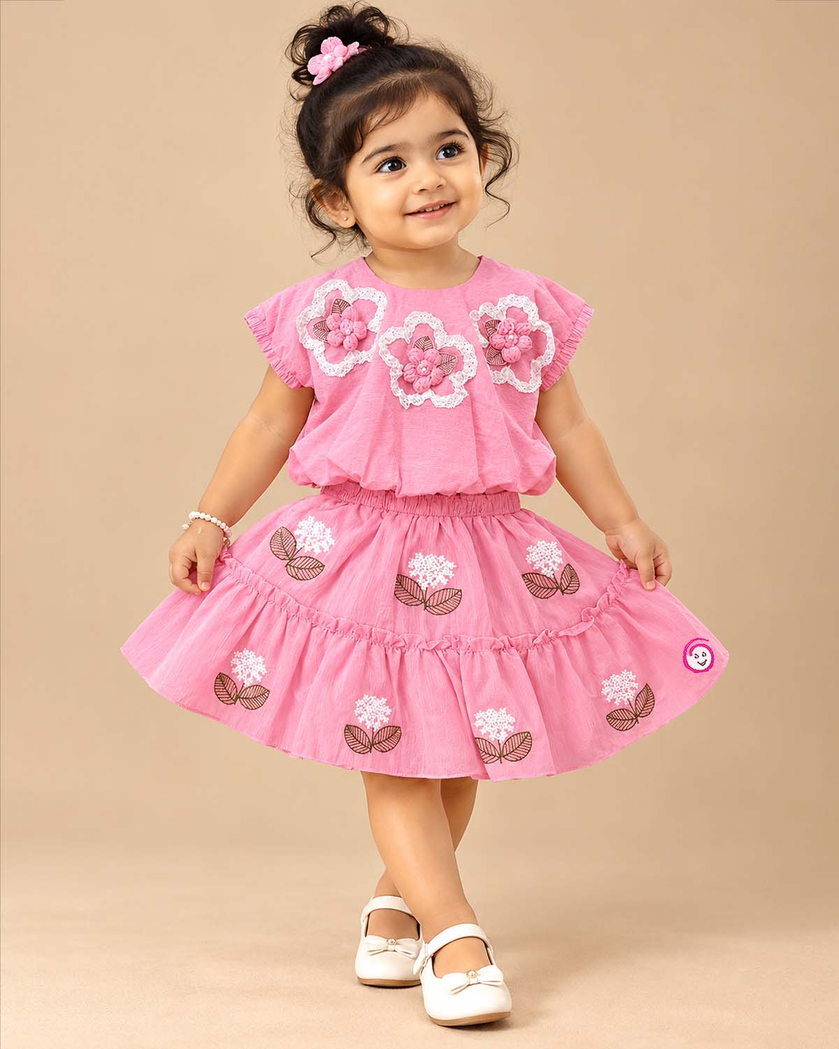 Textured floral applique blouson top paired with embroidered tiered skirt baby party wear dress.